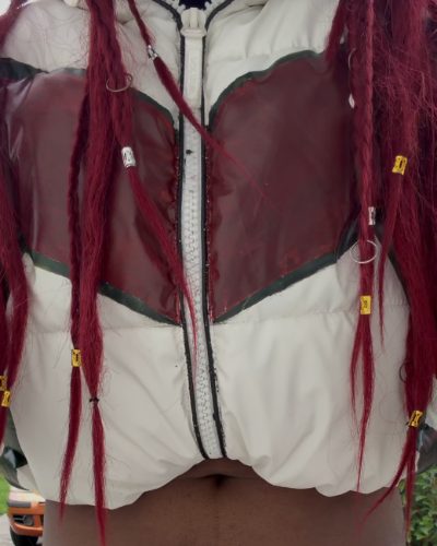 Dettaglio della giacca: pannelli dipinti a mano in rosso scuro con contorni neri sul nylon bianco