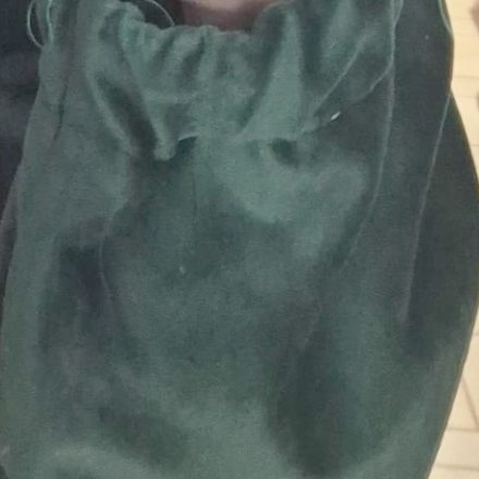 Polsino arricciato in tessuto verde, montato e fermato prima della cucitura definitiva